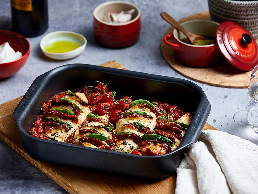 Hasselback-kylling med mozzarella og pesto i sterk tomatsaus.